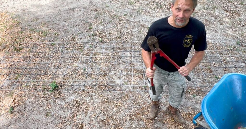 man showing the cutters you'll need to cut the cattle panel to build the tomato cage